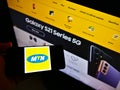 Person holding cellphone with logo of South African telecommunications company MTN Group on screen in front of web page. Royalty Free Stock Photo