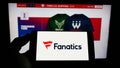 Person holding cellphone with logo of US online sportswear retailer Fanatics Inc. on screen in front of business webpage. Royalty Free Stock Photo