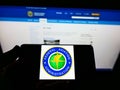 Person holding cellphone with seal of American agency Federal Aviation Administration (FAA) on screen with web page.