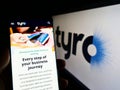 Person holding cellphone with webpage of Australian fintech company Tyro Payments Limited on screen with logo.