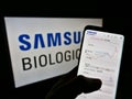 Person holding cellphone with webpage of biotechnology company Samsung Biologics Co Ltd on screen in front of logo. Royalty Free Stock Photo
