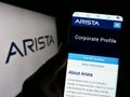 Person holding cellphone with webpage of computer networking company Arista Networks Inc. on screen with logo. Royalty Free Stock Photo