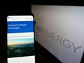 Person holding cellphone with webpage of German solar energy company Blue Elephant Energy AG on screen with logo.