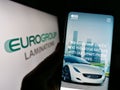 Person holding cellphone with webpage of Italian company EuroGroup Laminations SpA on screen with logo.