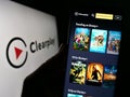 Person holding cellphone with webpage of parental control company Clearplay Inc. on screen in front of logo.