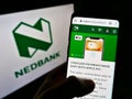 Person holding cellphone with webpage of South African bank Nedbank Group Limited on screen in front of logo.