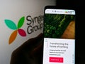 Person holding cellphone with webpage of Swiss agriculture company Syngenta Group on screen in front of logo. Royalty Free Stock Photo