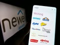 Person holding cellphone with webpage of US consumer goods company Newell Brands Inc. on screen with logo.