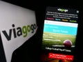 Person holding cellphone with webpage of US ticket exchange platform company Viagogo on screen in front of logo.
