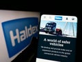 Person holding cellphone with website of automotive company Haldex Europe SAS on screen in front of logo. Royalty Free Stock Photo