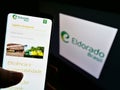 Person holding cellphone with website of Brazilian pulp manufacturer Eldorado Brasil Celulose on screen with logo.