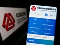 Person holding cellphone with website of China Securities Regulatory Commission (CSRC) on screen with logo.