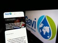 Person holding cellphone with website of health partnership Gavi, the Vaccine Alliance on screen with logo.