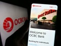 Person holding cellphone with website of Oversea-Chinese Banking Corporation (OCBC Bank) on screen with logo. Royalty Free Stock Photo