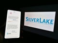 Person holding cellphone with website and portfolio of US private equity company Silver Lake on screen in front of business logo. Royalty Free Stock Photo