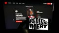 Person holding cellpohone with logo of Israeli cultured meat company Redefine Meat Ltd. on screen in front of webpage.