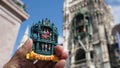 person holding a colorful refrigerator magnet of Munich, Germany