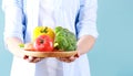 Person holding colorful vegetables empty space blue background,organic food,online market Royalty Free Stock Photo