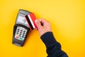 Person holding credit card or debit card against POS payment terminal