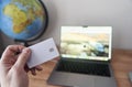 Person holds credit card in front of computer for online transaction Royalty Free Stock Photo