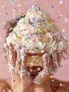 A person holding a cupcake with sprinkles and confetti, AI