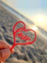 Person holding fingers hand stick shape red heart and word Love background sea Royalty Free Stock Photo