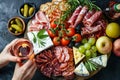 A person is holding a glass of wine next to a platter of food Royalty Free Stock Photo