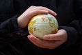 Person holding a globe model with hands Royalty Free Stock Photo