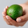 A person holding a green avocado in their hand Royalty Free Stock Photo