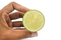 A person holding a half cut round and tasty lemon fruit in his hand with his finger Royalty Free Stock Photo