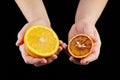 Orange and blood or red orange fruit halves in hands on black background Royalty Free Stock Photo