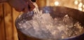 A person holding an ice bucket getting ready to pour freezing water onto themselves after a sauna session. Royalty Free Stock Photo