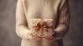 Person Holding Knitted Gift with Satin Ribbon. hands holding knitted gift, perfect for needlework enthusiasts Royalty Free Stock Photo