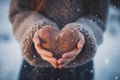 A person holding a knitted heart in their hands