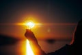 Person Holding a Lightbulb Full of Sollar Energy in the Sunset