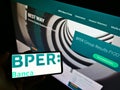 Person holding mobile phone with business logo of Italian bank BPER Banca SpA. on screen in front of company web page.