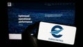 Person holding mobile phone with logo of air traffic management organization Eurocontrol on screen in front of web page.