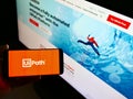 Person holding mobile phone with logo of automation software development company UiPath Inc. on display in front of web page. Royalty Free Stock Photo