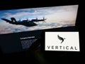 Person holding mobile phone with logo of British aircraft company Vertical Aerospace Ltd. on screen in front of web page.