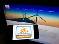 Person holding mobile phone with logo of Mexican Grupo Comercial Chedraui S.A.B. de C.V. on screen in front of web page.