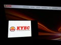 Person holding mobile phone with logo of Taiwanese company King Yuan Electronics Corp. (KYEC) on screen with webpage.