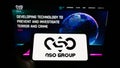 Person holding mobile phone with logo of technology company NSO Group Technologies Ltd. on screen in front of web page.