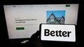 Person holding mobile phone with logo of US financial company Better Mortgage (Better.com) on screen with web page.