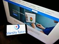 Person holding mobile phone with logo of US learning platform Varsity Tutors operated by Nerdy Inc. on screen with website.