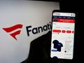 Person holding mobile phone with webpage of US online sportswear retailer Fanatics Inc on screen in front of logo. Royalty Free Stock Photo