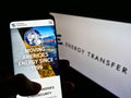 Person holding mobile phone website logo of US pipeline company Energy Transfer LP on screen in front of logo.