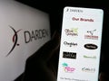 Person holding mobile phone with website of US gastronomy company Darden Restaurants Inc. on screen with logo.