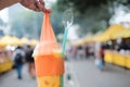 Person holding an orange smoothie with plastic handles attached to the cup Royalty Free Stock Photo