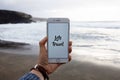 Person holding a phone with let`s travel text and a blurred beach in the background Royalty Free Stock Photo