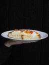 a person holding a piece of cake on a plate